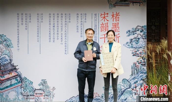 国家级非遗(杭州雕版印刷技艺)代表性传承人黄小建(左)将重新刻印的《湖山胜概》捐赠给杭州国家版本馆 晓风书屋 供图