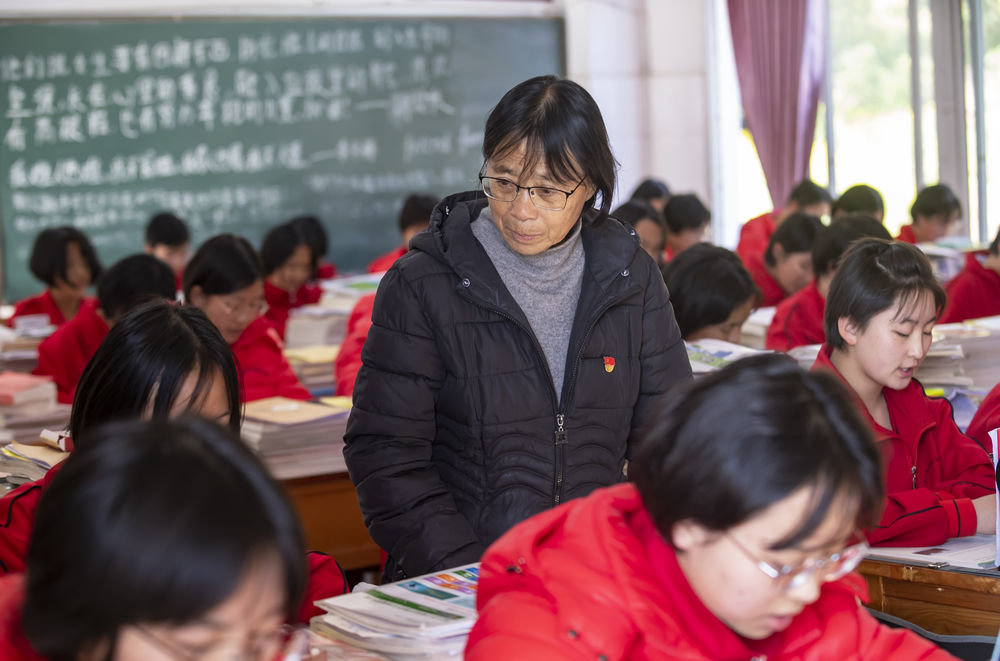 云南丽江华坪女子高级中学校长张桂梅(中)在教室里检查学生上课情况(2020年12月1日摄)。新华社记者 陈欣波 摄