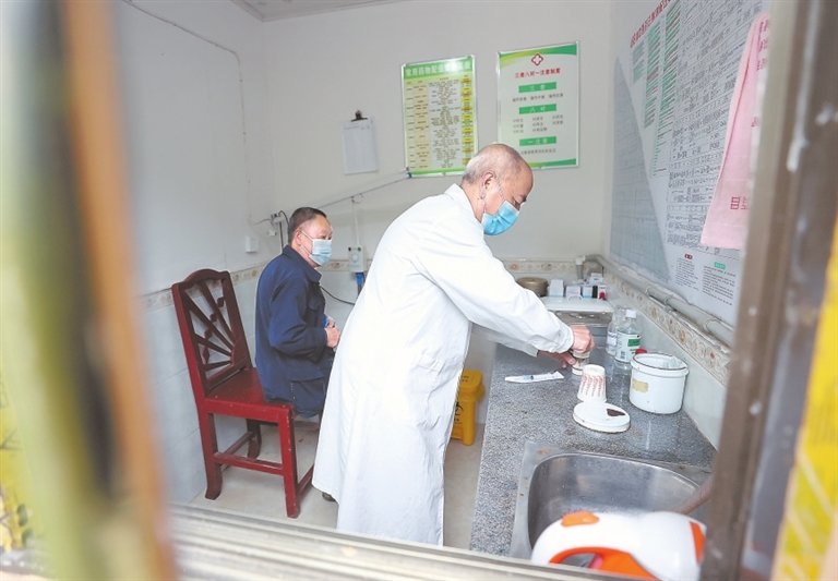 在铜鼓县高桥乡白石村卫生室,杨福盛准备为村民注射