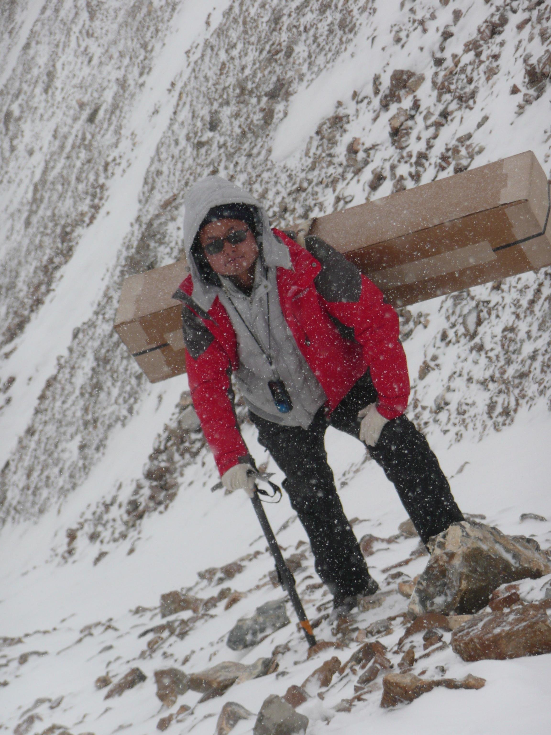 2020年,研究人员搬运气象设备上山途中遇到风雪。