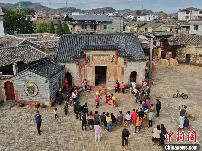 图为无人机航拍不少游客和村民在南丰县石邮村的傩神庙前观看精彩的南丰跳傩表演。　刘力鑫 摄
