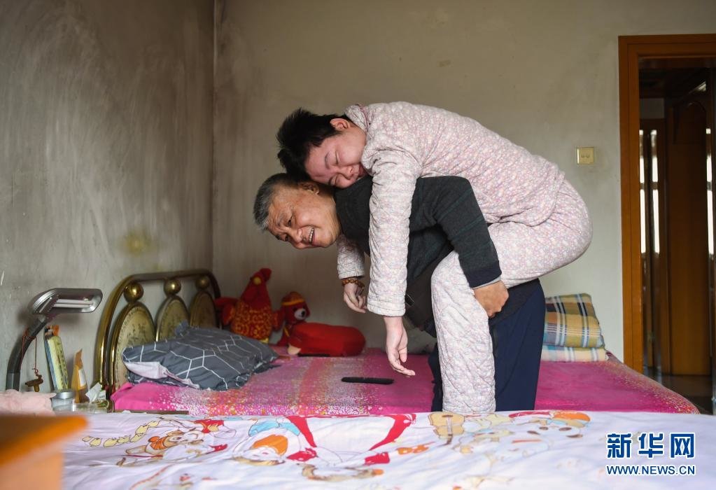 华波背起华楠，准备做康复训练。新华社记者 邹竞一 摄