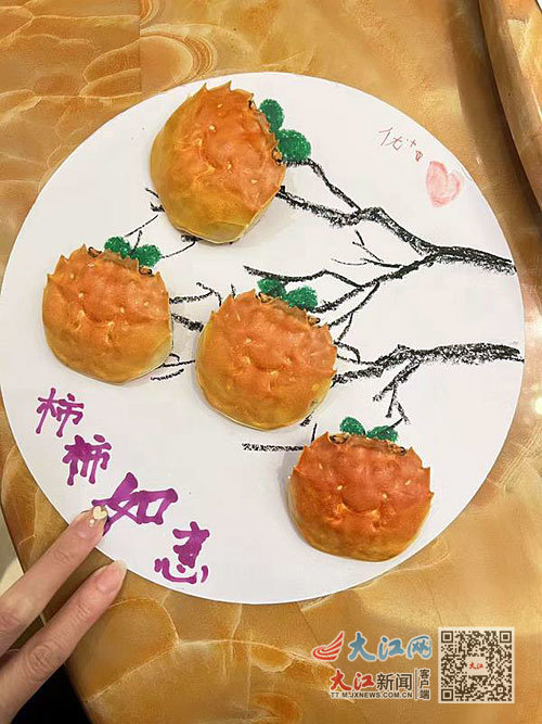 林黛琴女士用螃蟹壳和画笔等制作的柿子图，并提写了“柿柿如意”字样。