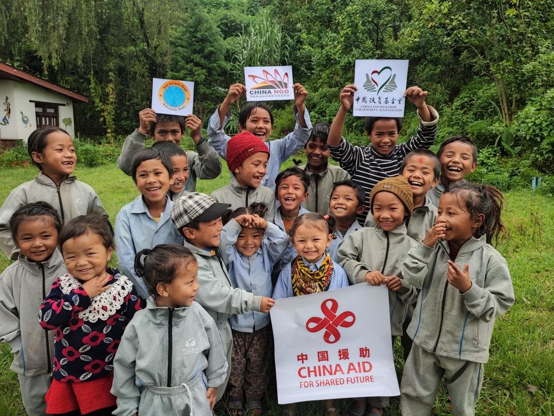 ▲保尔·曼德尔学校的孩子们在粮食发放仪式上乐开了花,值得一提的是,孩子们穿的灰色套装,也来自中国乡村发展基金会温暖包项目捐赠。