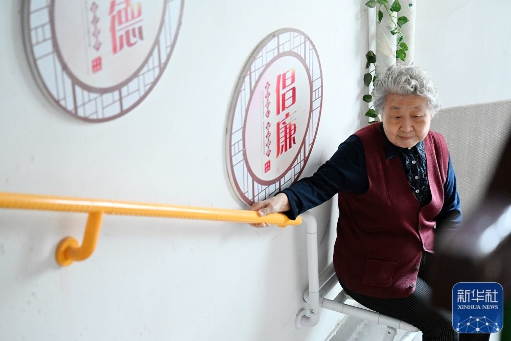 ↑ 在天津市和平区文化村社区，楼道内加装了扶手和折叠椅便于老人上下楼（10月27日摄）。