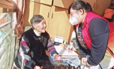 洪倩（右）给老人送照片。记者秦璟 摄