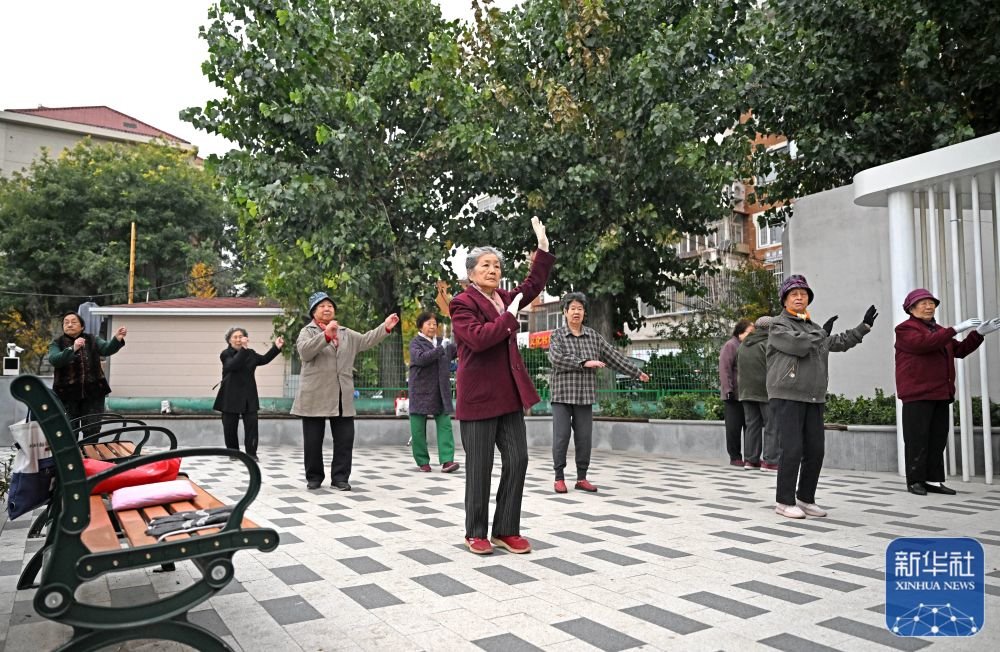 ↑ 在天津市和平区文化村社区，老年人在适老化改造中改建的小区广场上跳舞（10月28日摄）。
