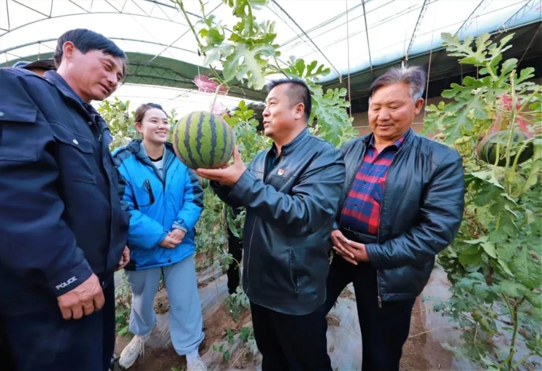 在甘浚镇速展村的西瓜大棚里,村党支部书记王鑫与村民面对面地进行