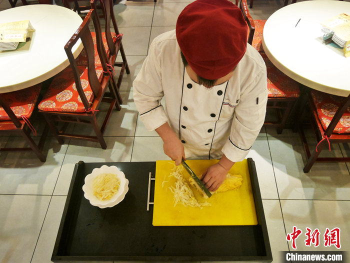 图为11月14日，吉林市一满族火锅店，厨师现场加工酸菜。 <a target='_blank' href='/'>中新社</a>记者 石洪宇 摄