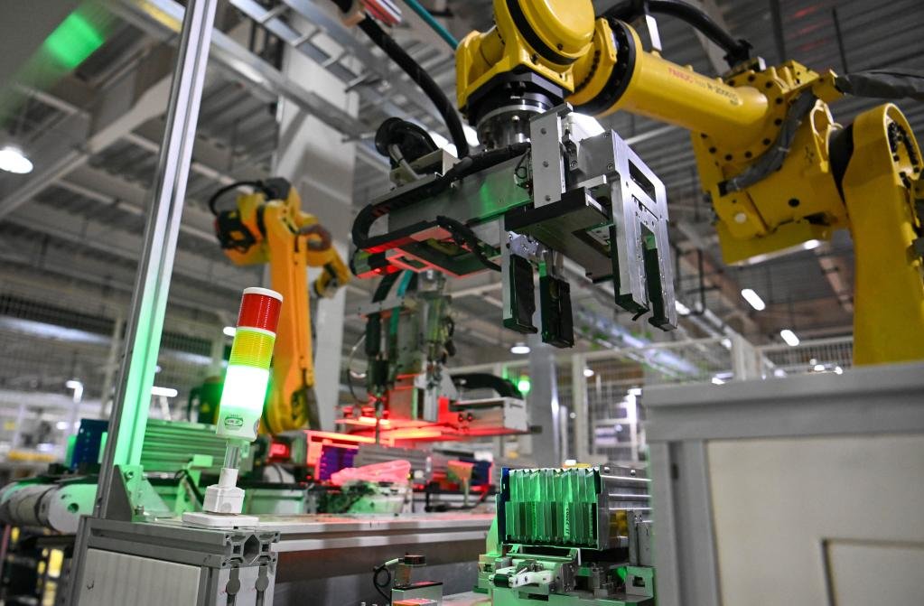 2022年7月25日，在天津荣盛盟固利新能源科技有限公司模组车间，工业机器人在生产线上搬运动力电池模组。新华社记者 孙凡越 摄