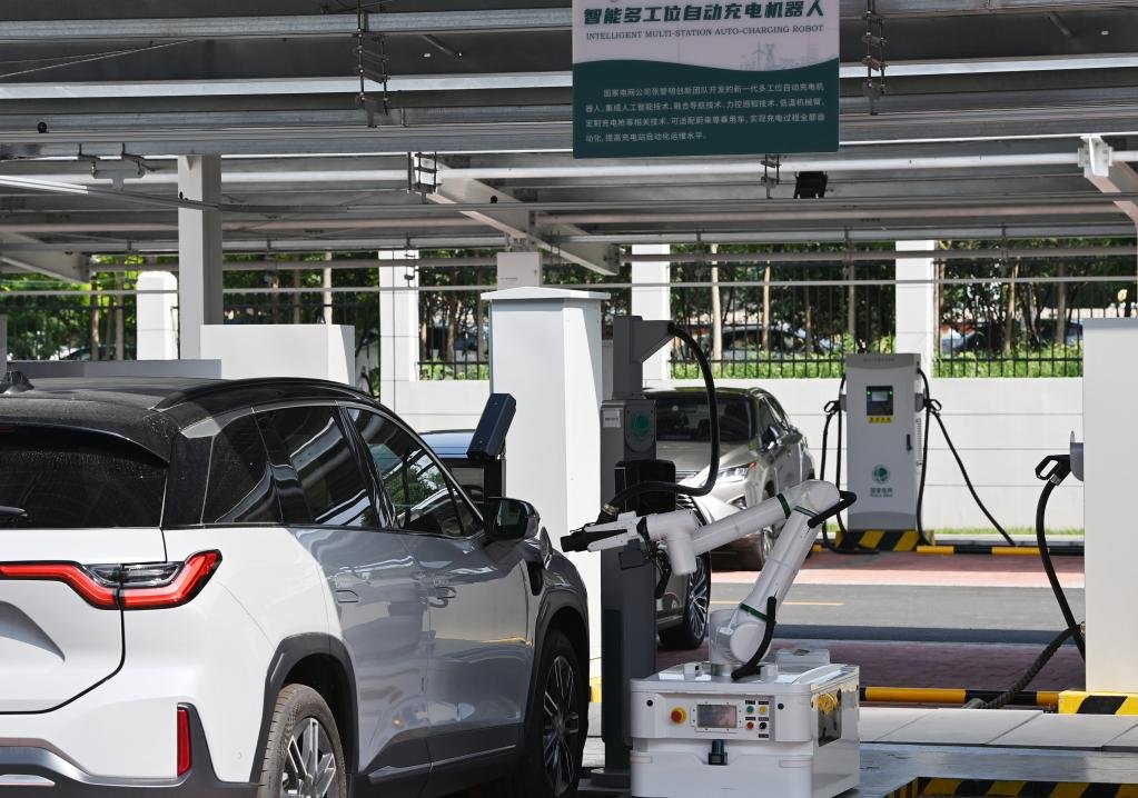 在天津津门湖新能源车综合服务中心，机器人正在为一辆新能源汽车充电（2021年8月18日摄）。新华社记者 李然 摄