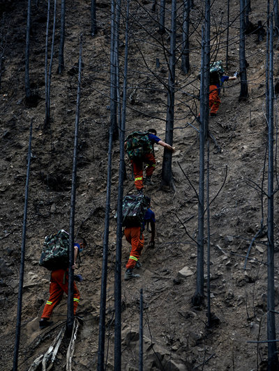 消防员把牺牲战友掉在火场上的东西拿回来。