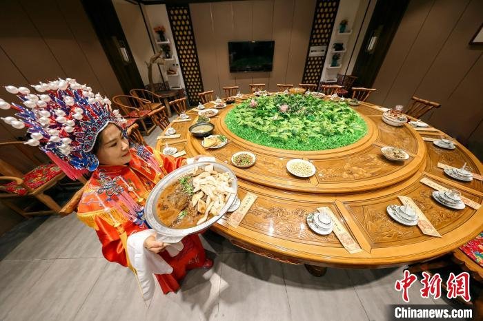 色香味俱佳的“全鱼宴”菜品,由身着古装的服务员端上桌。 王耀 摄