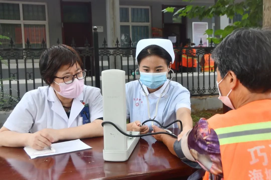 2022年8月16日,河北省邯郸市永年区中医院的医护人员正在为环卫工人量血压。图/IC photo
