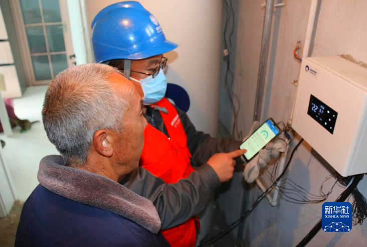 2022年11月，张北县油篓沟供电所工作人员到谢丽成家检查电供暖运行情况。（受访单位供图）