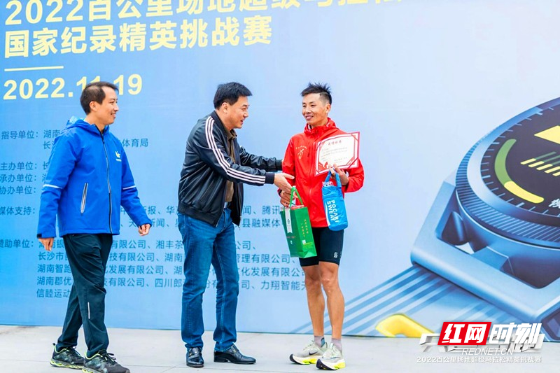 湖南体育职业学院副院长安忠（中）为曾文波颁奖。