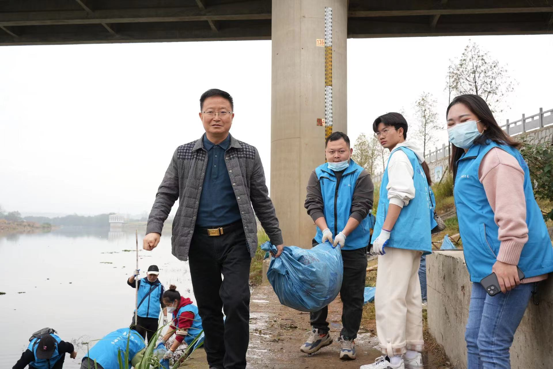 溆浦县河长办常务副主任何国发正在组织清理溆水河岸漂浮物(郑林文摄)