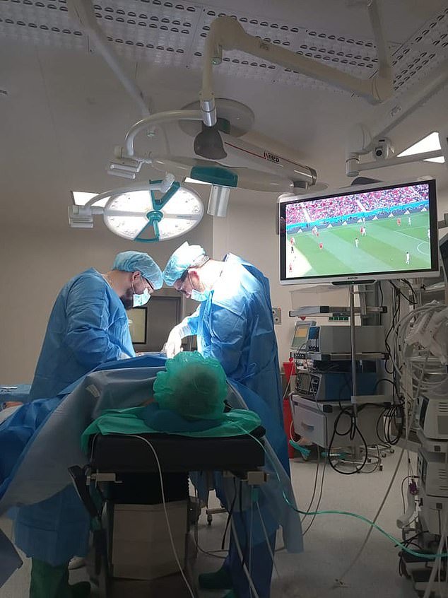 医生们正在为男子进行手术，病人在观看世界杯比赛