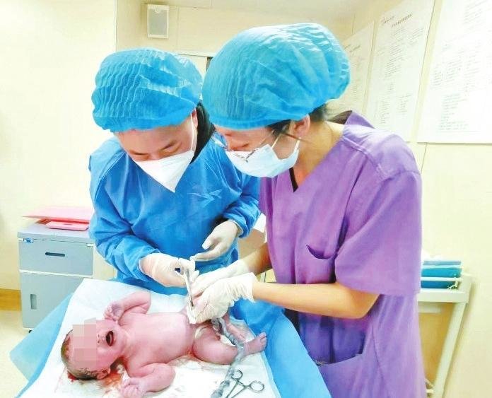 一位宝爸在助产士指导下剪脐带