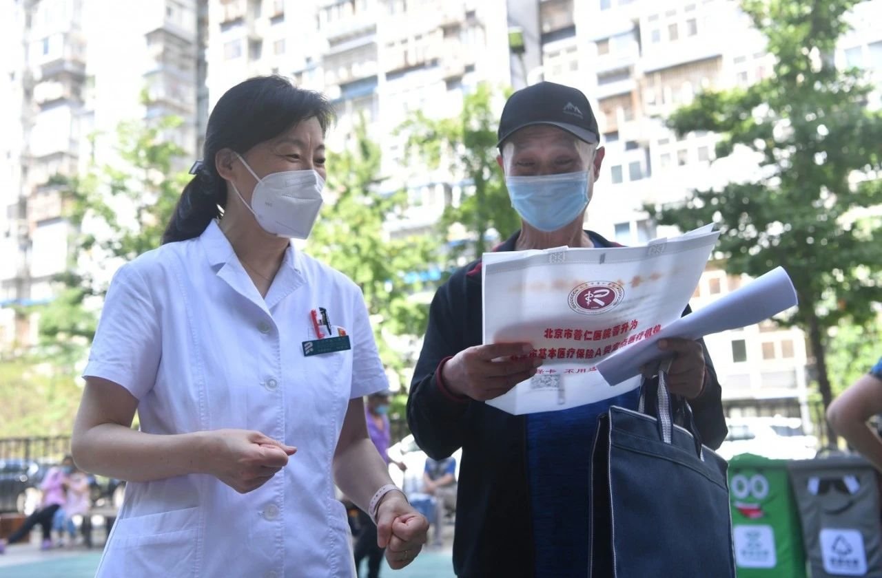 2022年7月6日下午，北京义诊现场，一名医生在为居民介绍医保政策。 新京报记者 李木易 摄