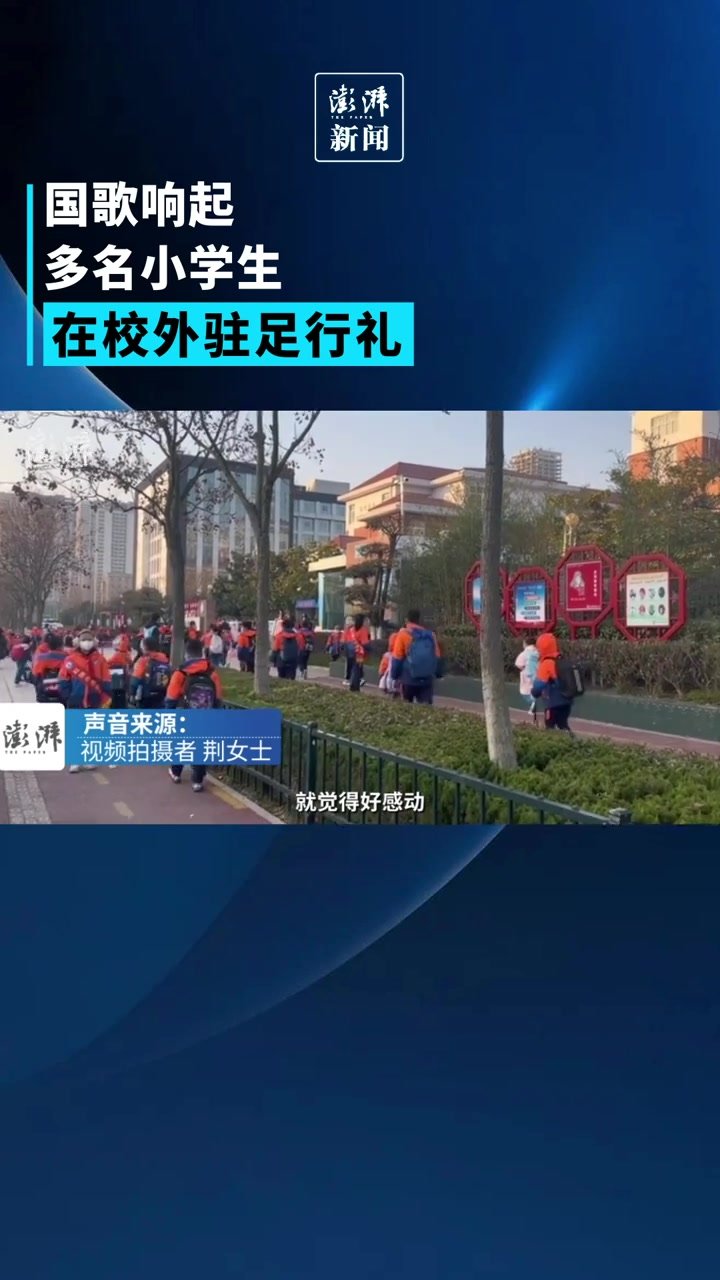 国歌响起，多名小学生在校外驻足行礼