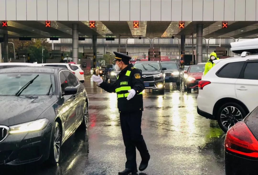 12月4日，在绕城高速包河大道道口，工作人员冒雨执勤，引导车辆有序通行。全媒体记者 王骏超 摄