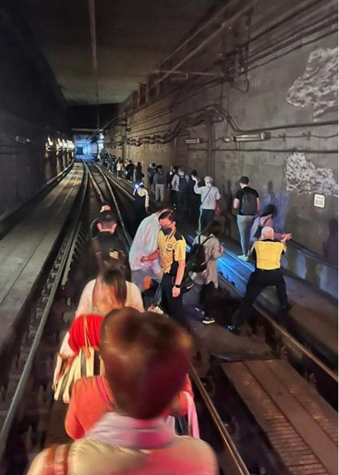 车内乘客沿路轨返回月台。（图片来源：香港东网）