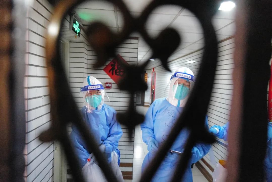 2022年3月16日，广东省深圳市，防疫工作人员上门为居家隔离市民做核酸检测。
