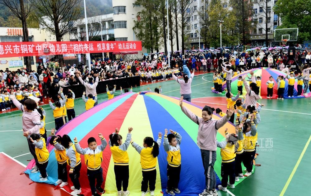 2022年12月8日，江西省德兴市铜矿中区幼儿园小朋友的彩虹伞表演，吸引众多群众前来观看。