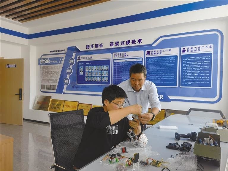 12月1日，焦悦峰技能大师工作室领衔人焦悦峰（右）正在指导员工实践操作。受访者供图