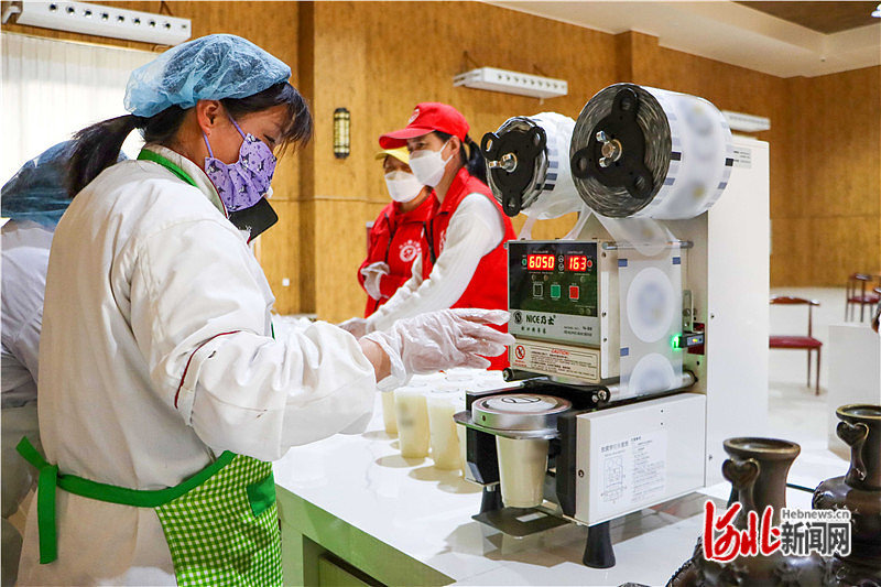 图１：唐山市丰润区新军屯镇悦新社区第五食堂工作人员为居民准备饮品。通讯员史冠昭摄.jpg
