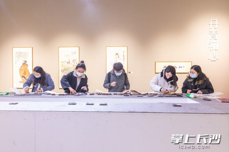 “复现”荣宝斋350周年木版水印特展上,记者们在体验木版水印。