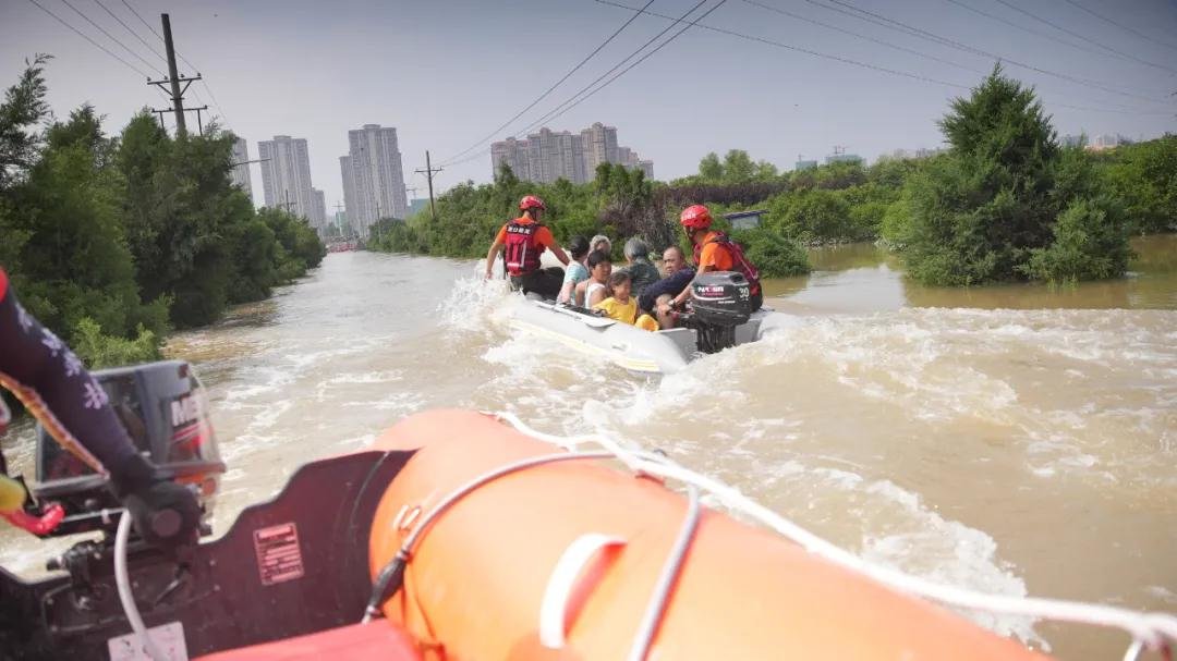 图：一艘冲锋舟大约可以运送5到6名受困群众，救援队在水上穿梭不停。