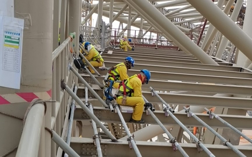 高温之下，工人们正在为体育场安装钢结构。受访者供图