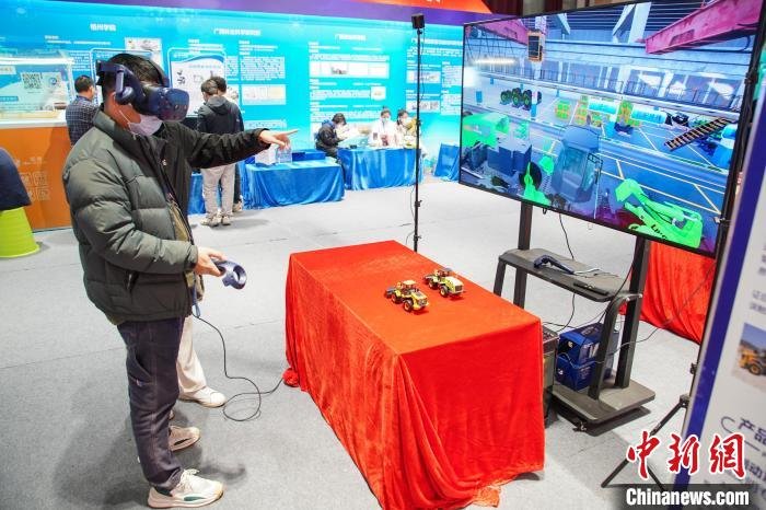 图为参观者穿戴虚拟现实(VR)设备体验装载机组装。　陈冠言 摄