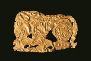 【虎噬羊纹金饰片&middot;战国&middot;清水县刘坪出土】工艺技法采用常见的锤碟法，在薄的金片的背面錾刻虎形，正面隆起，边缘剪切，四角有钉孔。虎呈蹲踞形，眼、鼻、耳、嘴、齿、爪都十分清晰，虎张嘴，伸沟状前爪抓住一羊。