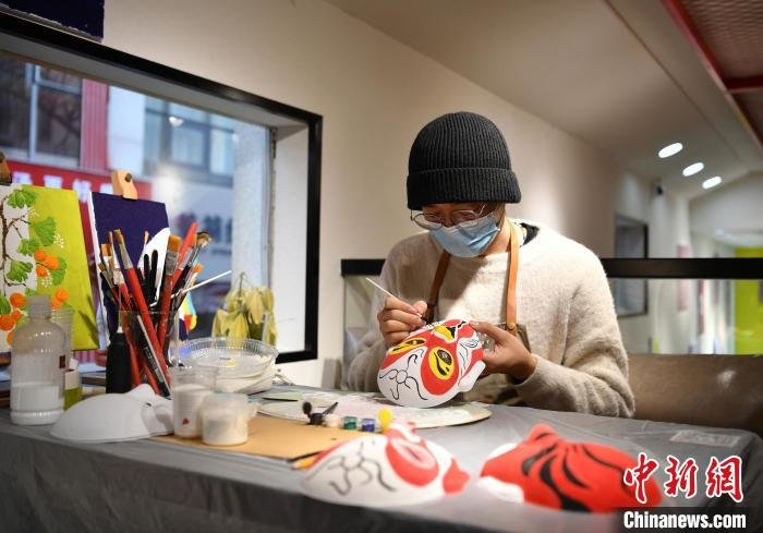 图为12月9日，石家庄市裕华区一家文创非遗体验馆，工作人员绘制戏曲人物脸谱。　翟羽佳 摄