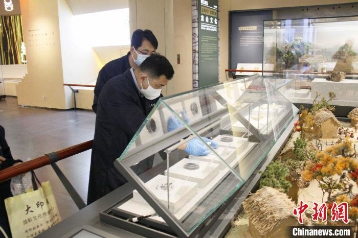 日照市博物馆工作人员正在布展炭化水稻。　日照市博物馆供图