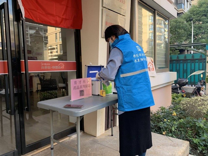 温州瑞安市安阳街道育才社区的群众来到社区药品共享驿站,从一旁的药箱中取走合适的药品。新华网发
