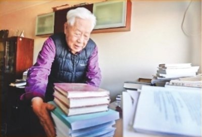 中南财经政法大学九旬教授赵德馨在家中清理案头书籍和资料。