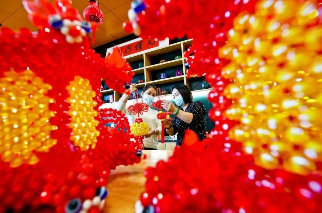 ↑新春佳节临近，甘肃省张掖市甘州区妇联工作人员组织近百名巾帼巧手绣娘，制作串珠红灯笼、彩绘宫灯、吉祥醒狮、虎娃等手工艺品。