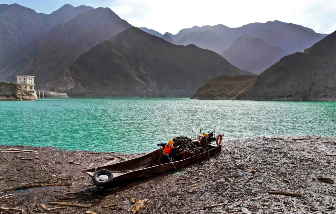 ↑2022年10月28日，黑河上游张掖龙首二级水电站坝区河道上，清理漂浮物的船只往来穿梭，来自甘肃电投河西水电公司的工作人员和青年志愿者们在打捞、清运漂浮物，确保母亲河“水清、河畅”。据介绍，该项工作已持续多年。