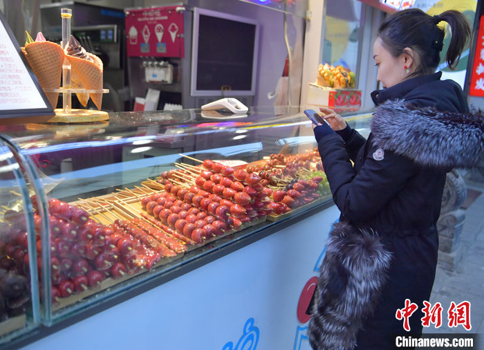 图为长春市民在选购冰糖葫芦。 中新社记者 张瑶 摄