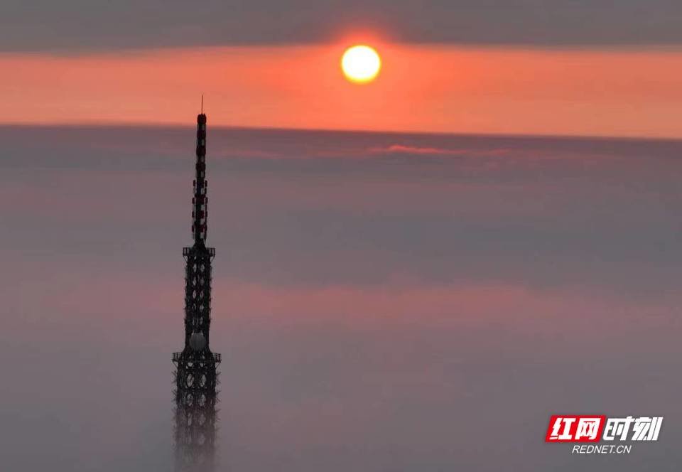 红彤彤的旭日穿破云层露出圆圆的笑脸。（曹正平摄影）