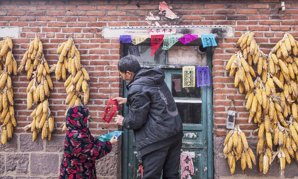 来逢强正在张贴“过门笺”。陈光金 摄