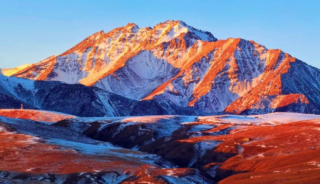↑2022年的第一缕阳光播撒在位于甘肃省张掖市肃南裕固族自治县大河乡的巴尔斯雪山和马蹄乡临松雪山上，祁连山雪峰成为了“金山”，祁连山麓呈显出勃勃生机。