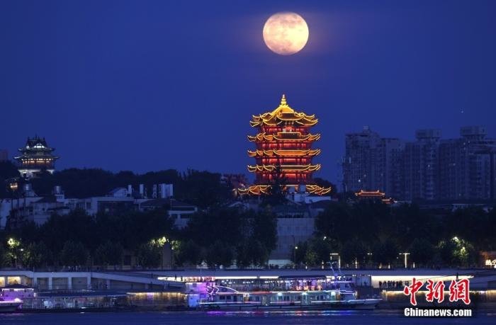 资料图：一轮“超级月亮”从黄鹤楼旁缓缓升起。图片来源：视觉中国
