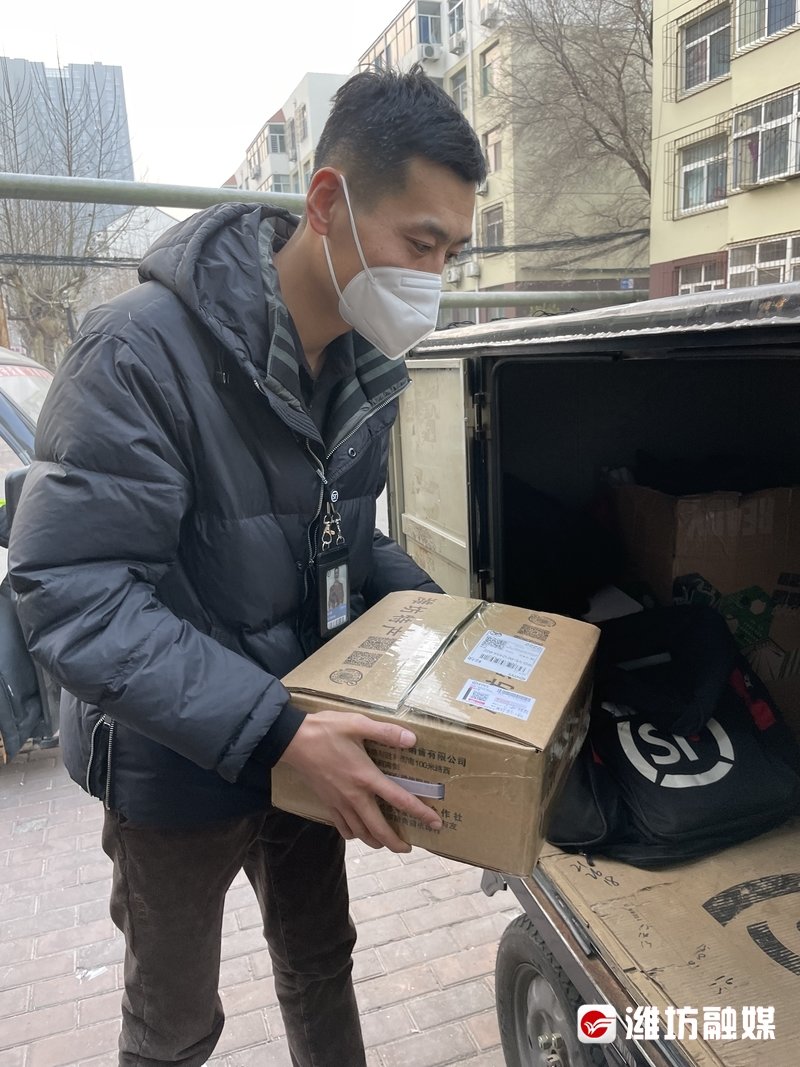 网点业务量非常大，刘大鹏帮快递员往快递车上装快件。