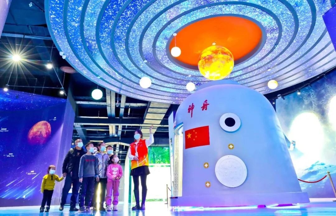 ↑2022年1月19日，位于甘肃省张掖市临泽县的张掖科技馆航天科技知识普及区内，工作人员向家长和小朋友介绍航天知识。