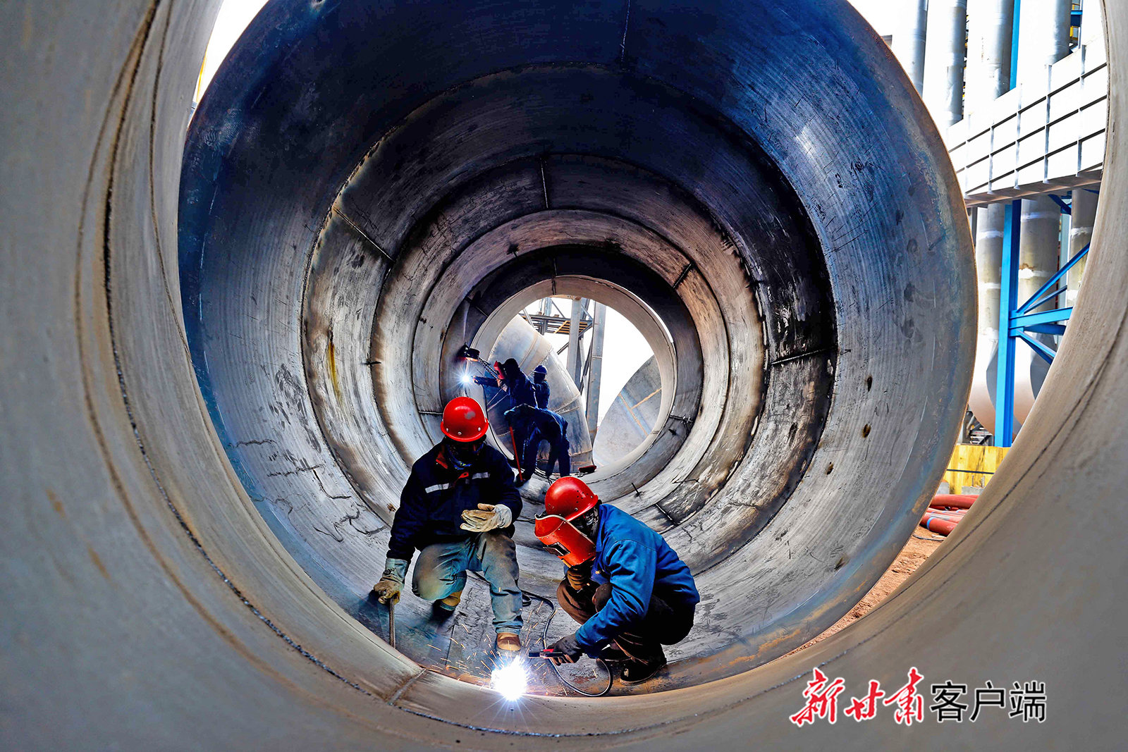 ▲2022年11月15日，張掖市經濟技術開發區循環經濟示范園，河西硅業新材料20萬噸硅系新材料綜合利用項目建設現場，工人們正在忙碌地進行罐體的焊接和安裝。新甘肅·甘肅日報通訊員 王將 陳海